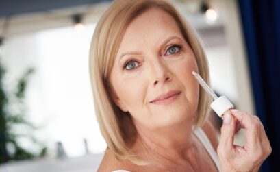 Senior woman using anti wrinkle serum in the bathroom