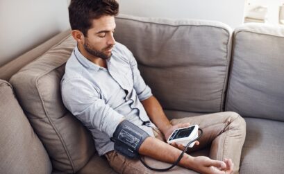 Shot of a young man taking his own blood pressure readings with a blood pressure monitor at home